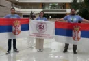 Tri srpska studenta drže zastavu Srbije i zastavu Fakulteta tehničkih nauka iz Čačka nakon osvajanja nagrade na Huawei ICT takmičenju 2024/2025.