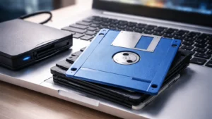 Plava 3,5-inčna disketa i USB flopi drajv pored modernog laptopa