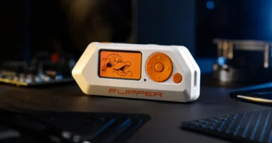 Flipper Zero uređaj na tamnom stolu uz modernu tehnološku opremu i osvetljenje