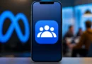 Pametni telefon sa ikonicom aplikacije za online zajednice i diskusije, uz zamućen Meta logo u pozadini.